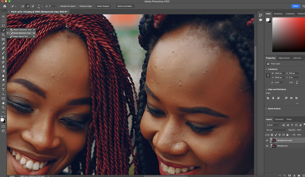 Screenshot of the Photoshop artboard with an image of two ladies looking into a phone.